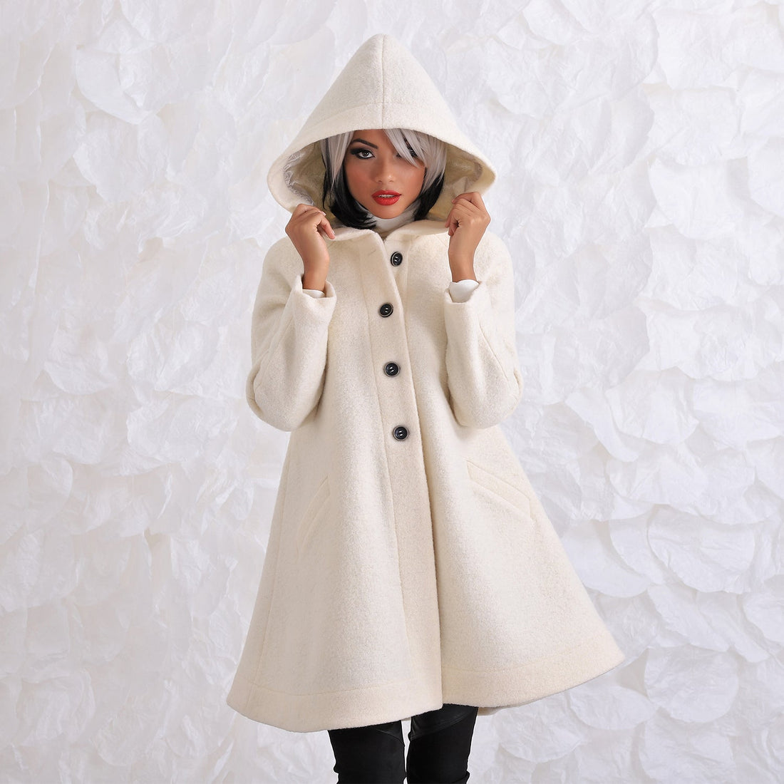 woman in white wool hooded coat with black buttons in A shape 